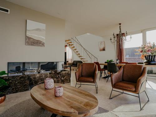 a living room with chairs and a table and a staircase at Apartment De Zeeparel by Interhome in Egmond aan Zee