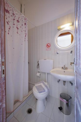 a bathroom with a toilet and a sink at LITHOS by the sea in Neo Itilo