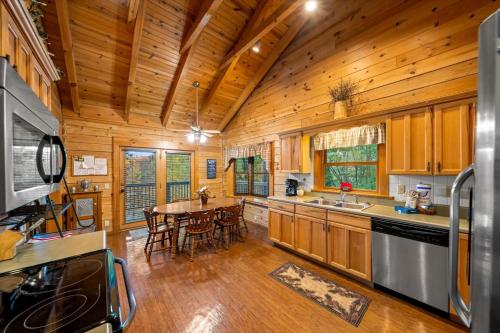 a kitchen and dining room with a table in a cabin at Dreamcatcher CV By Colonial Properties in Gatlinburg