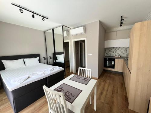 a bedroom with a bed and a table and a kitchen at Double studio Petra B2-5 in Byala
