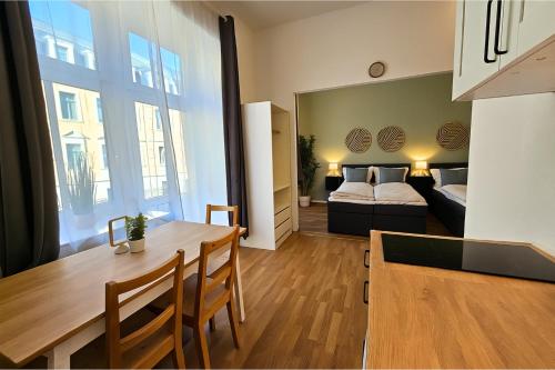 a kitchen and a living room with a bed and a table at LUMA Apartments in Dresden
