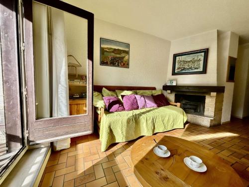 ein Wohnzimmer mit einem Bett und einem Kamin in der Unterkunft Charmant T2 avec coin montagne, 6 couchages, Monêtier les Bains, proche commerces et navettes ski - FR-1-330F-35 in Le Monêtier-les-Bains