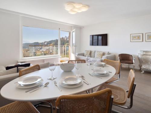 uma sala de jantar com uma mesa e cadeiras brancas em Apartment Clair-Azur A 41 by Interhome em Crans-Montana