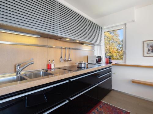 uma cozinha com pia de aço inoxidável e janela em Apartment Clair-Azur A 41 by Interhome em Crans-Montana