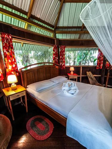 a bedroom with a bed and two tables and two lamps at Sun Creek Lodge in Punta Gorda