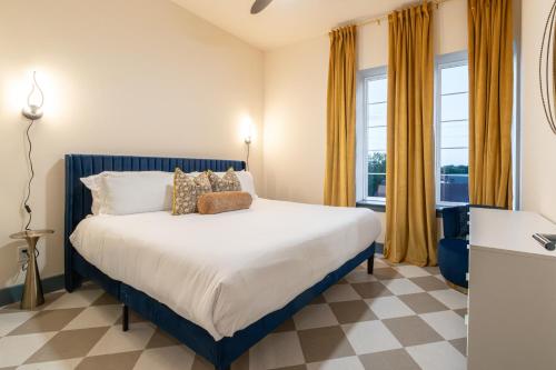 a bedroom with a large bed with yellow curtains at The Francesca - Apt 334 in Bryan