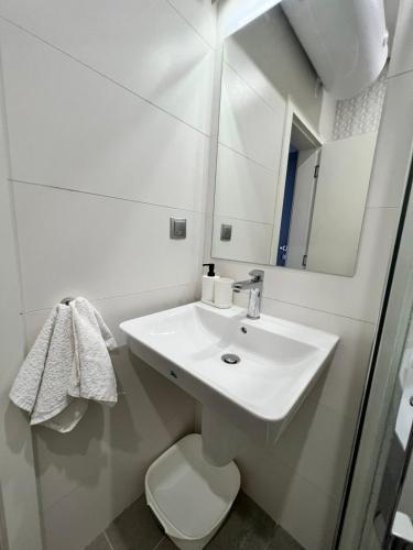 a white bathroom with a sink and a toilet at Double studio Petra B2-5 in Byala