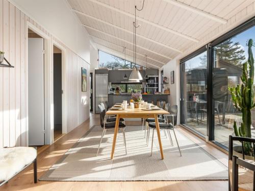 een eetkamer en keuken met een tafel en stoelen bij Holiday Home Talitha - 1-5km from the sea by Interhome in Hjørring
