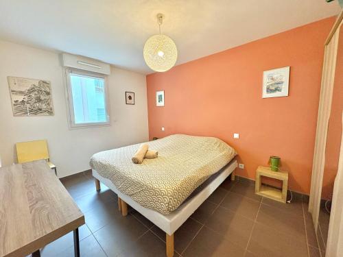 a bedroom with a bed with an orange wall at Appartement centrale à 100 m des plages Rue de Provence in Saint-Raphaël