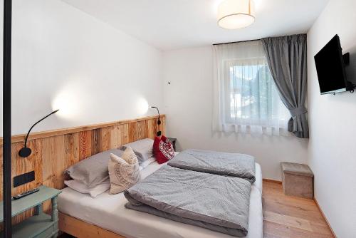 een slaapkamer met een bed en een televisie aan de muur bij Cesa Pattis in Campestrin