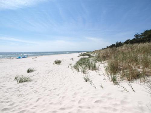 einen Sandstrand mit etwas Gras und dem Meer in der Unterkunft Holiday Home Alica - 200m from the sea by Interhome in Neksø