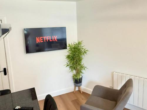 a living room with a tv on a wall at Newly Renovated Guesthouse with Free Parking in Reading