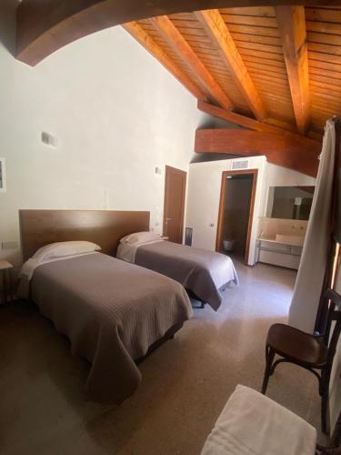 Un dormitorio con dos camas y techo de madera. en Agriturismo Cavendo Tutus, en Roma