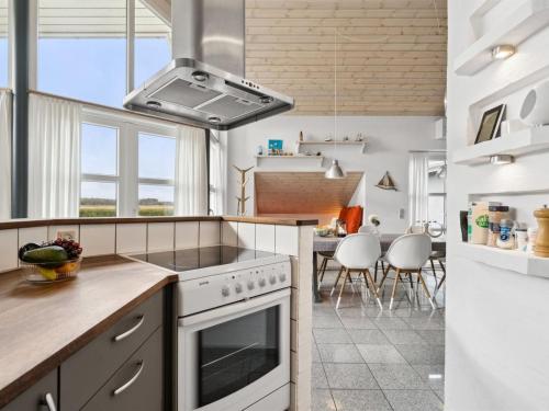 a kitchen with a stove top oven next to a table at Holiday Home Thrugels - 600m from the sea by Interhome in Hadsund