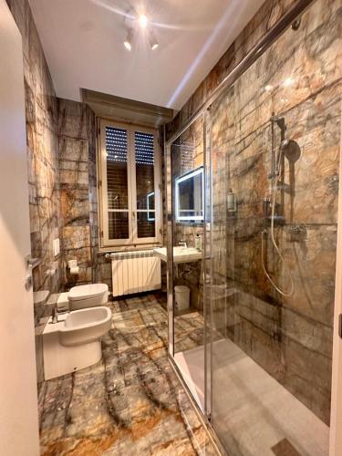 a bathroom with a shower and a toilet and a sink at Hermoso Housing Tortona in Tortona