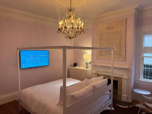 a bedroom with a canopy bed and a chandelier at Bosch House Rosé - Lila Suite in Savannah