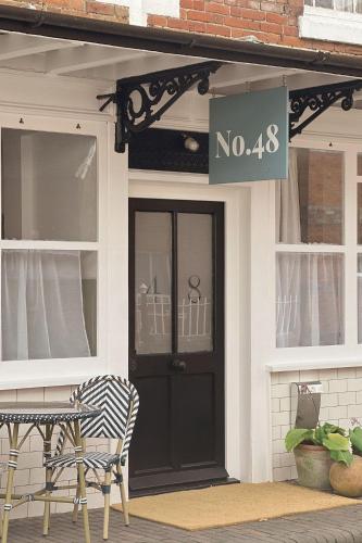 a house with a black door and a sign on it at No48 - Edwardian Shop Conversion in Pewsey in Pewsey