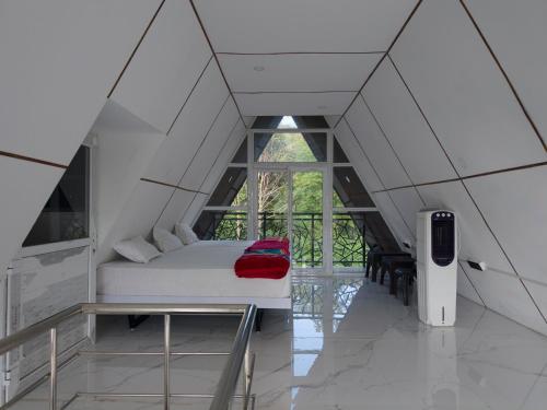 a bedroom with a white bed with a red blanket at Pine Trees Gold in Vagamon