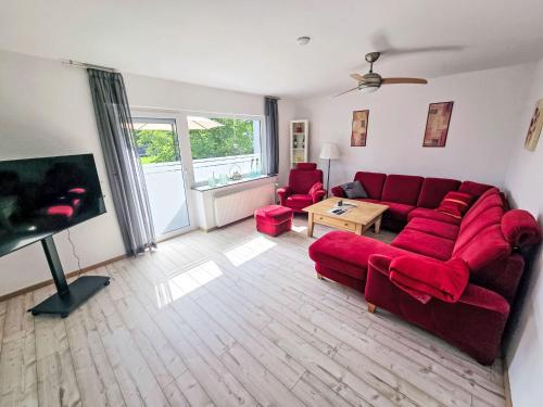 ein Wohnzimmer mit einem roten Sofa und roten Stühlen in der Unterkunft Apartment Lindenstraße-1 by Interhome in Wöbbel