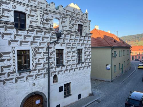 a white building with a design on the side of it at Apartmán Husova in Prachatice