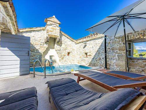 een patio met een zwembad en een parasol bij Holiday Home Franz by Interhome in Potpićan
