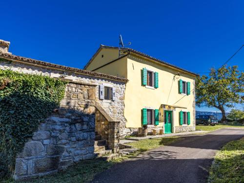 een oud stenen huis met groene luiken op een straat bij Holiday Home Franz by Interhome in Potpićan