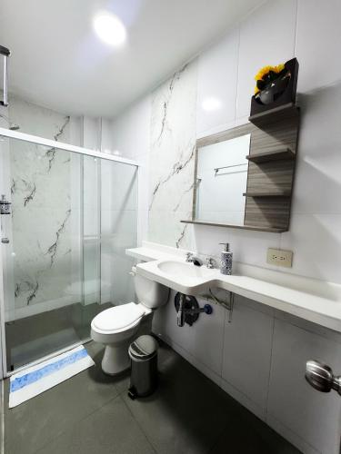 a bathroom with a toilet and a sink and a shower at Hotel la Ciudad in Barrancabermeja