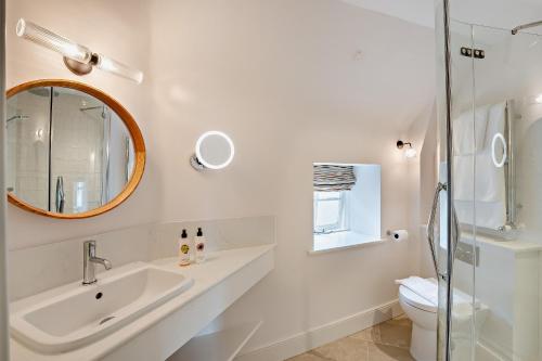 ein Badezimmer mit Waschbecken, Toilette und Spiegel in der Unterkunft Cub Bedroom Three in Eastdean