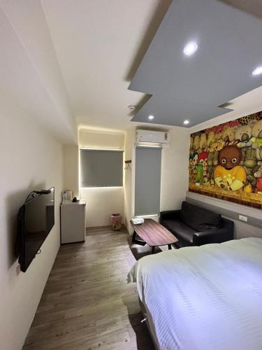 a room with a bed and a couch and a television at 逢甲Cartoon in Hsia-shih-pi