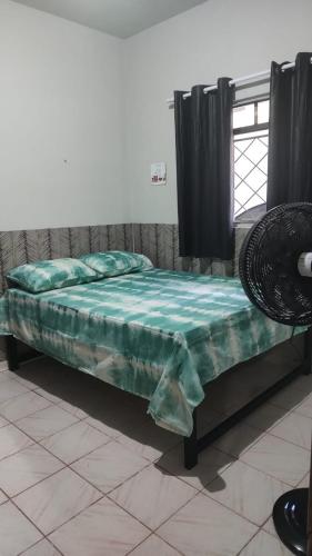 a bed in a room with a green sheet on it at 02 - Sinta-se em casa in Paragominas