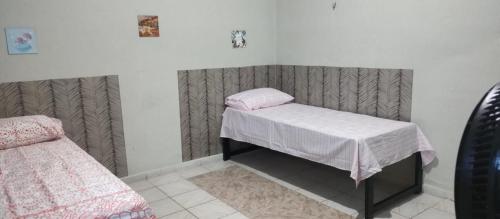 ein Zimmer mit einem kleinen Bett und einem rosa Kissen in der Unterkunft Sinta-se em casa in Paragominas