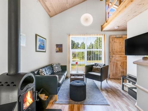 een woonkamer met een bank en een open haard bij Holiday Home Angantir - 4-8km from the sea by Interhome in Byrum