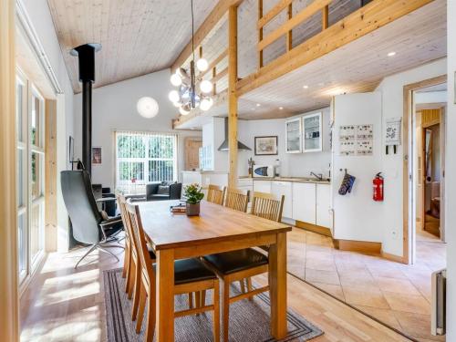 een keuken en eetkamer met een houten tafel en stoelen bij Holiday Home Angantir - 4-8km from the sea by Interhome in Byrum