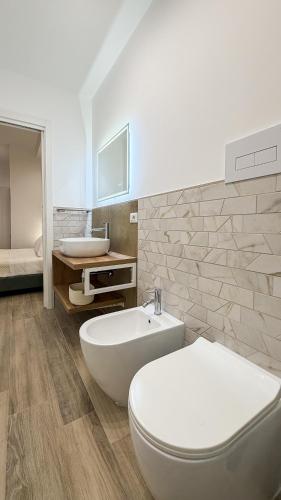 ein Badezimmer mit weißer Toilette und Waschbecken in der Unterkunft Street316 in Cinisi