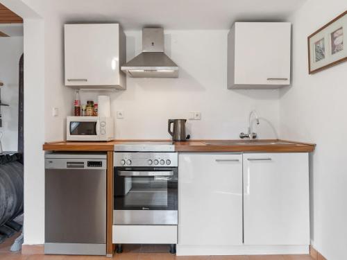 a kitchen with a stove and a microwave at Holiday Home Fish & Boat by Interhome in Hurka