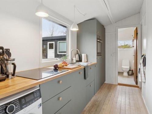 a kitchen with white cabinets and a window at Holiday Home Gun - 300m to the fjord by Interhome in Glostrup