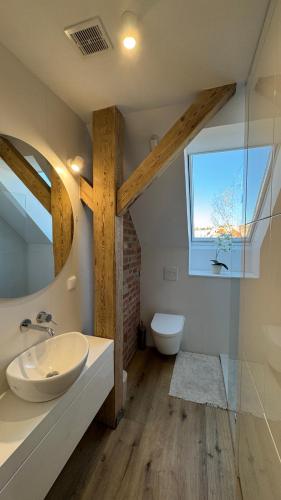 a bathroom with a white sink and a window at OPOLSKA WENECJA-apartament typu STUDIO z tarasem in Opole