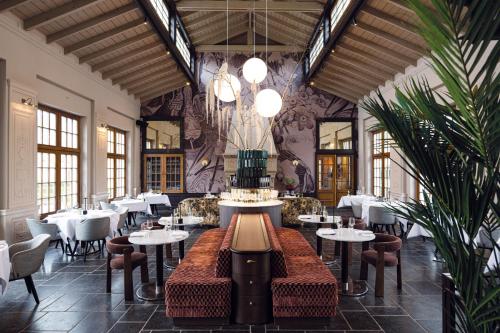 un restaurante con mesas, sillas y un pastel en Landgoed Altenbroek, en Voeren