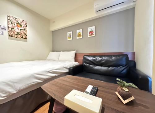 a room with a bed and a table and a couch at 逢甲Cartoon in Hsia-shih-pi