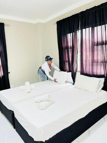 a man standing between two beds in a bedroom at Sunset in Durban