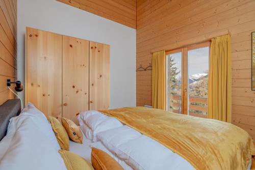 une chambre avec un lit et une grande fenêtre dans l'établissement Chalet Mouettes, à Riddes
