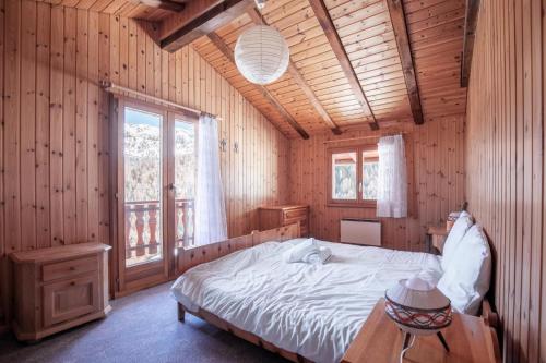 Un dormitorio con una cama en una habitación de madera. en Chalet La Caleche, en La Tzoumaz