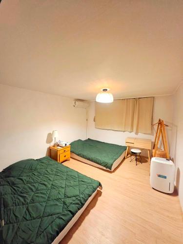 a room with two beds and a desk and a bed sidx sidx sidx at 윤 작가의 숙소 in Seoul