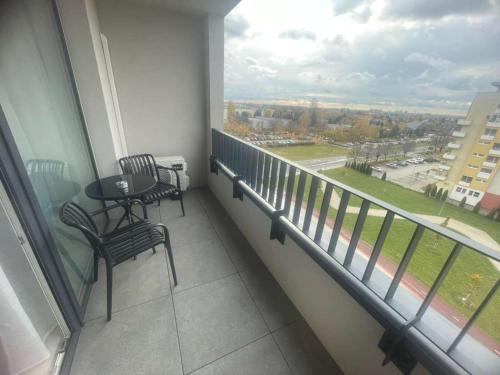 a balcony with a table and chairs and a large window at Apartmán P121 in Trnava