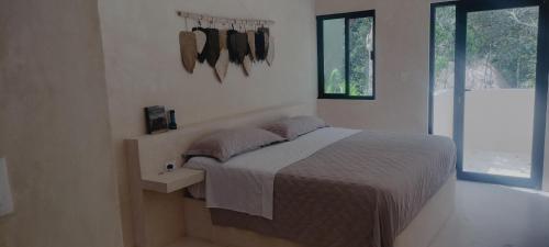 une chambre blanche avec un lit et une fenêtre dans l'établissement Casabel Tulum jungle experience, à Cobá