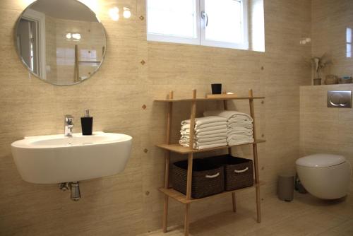 a bathroom with a sink and a toilet and a mirror at Møllehusets lejligheder i Ikast tæt ved Herning, Silkeborg og Århus in Ikast