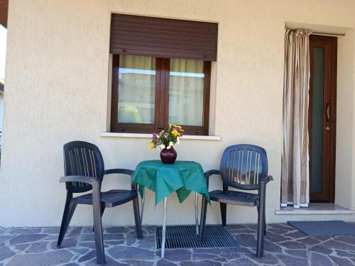 a table with two chairs and a vase with flowers at Al Centrale in Alano di Piave
