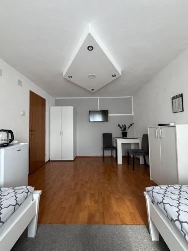 een woonkamer met 2 bedden en een eettafel bij Sobe kod bolnice Paprikovac in Banja Luka