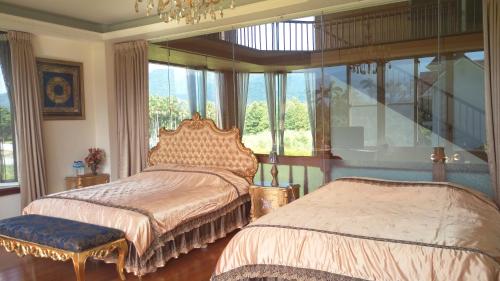 豐坪村的住宿－雲山水民宿逸翠軒會館，一间卧室设有两张床和窗户。