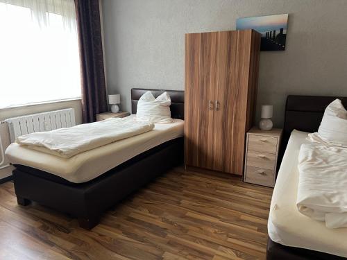 a bedroom with two beds and a wooden floor at Appartement am Löhner Bahnhof in Löhne